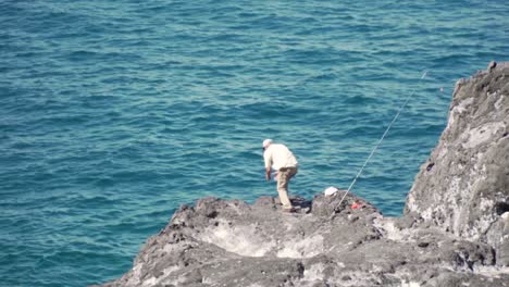 man fishing from coastal rocks