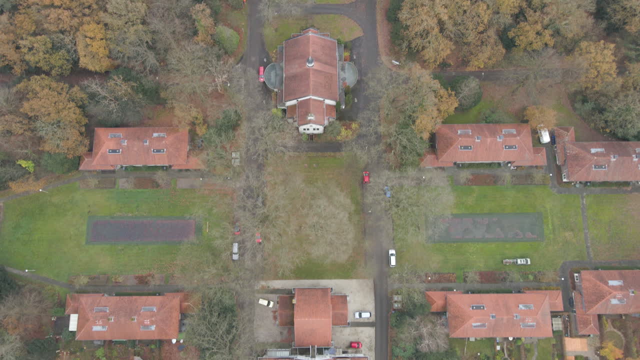 съемка сверху вниз красивого маленького города, окруженного деревьями осенью