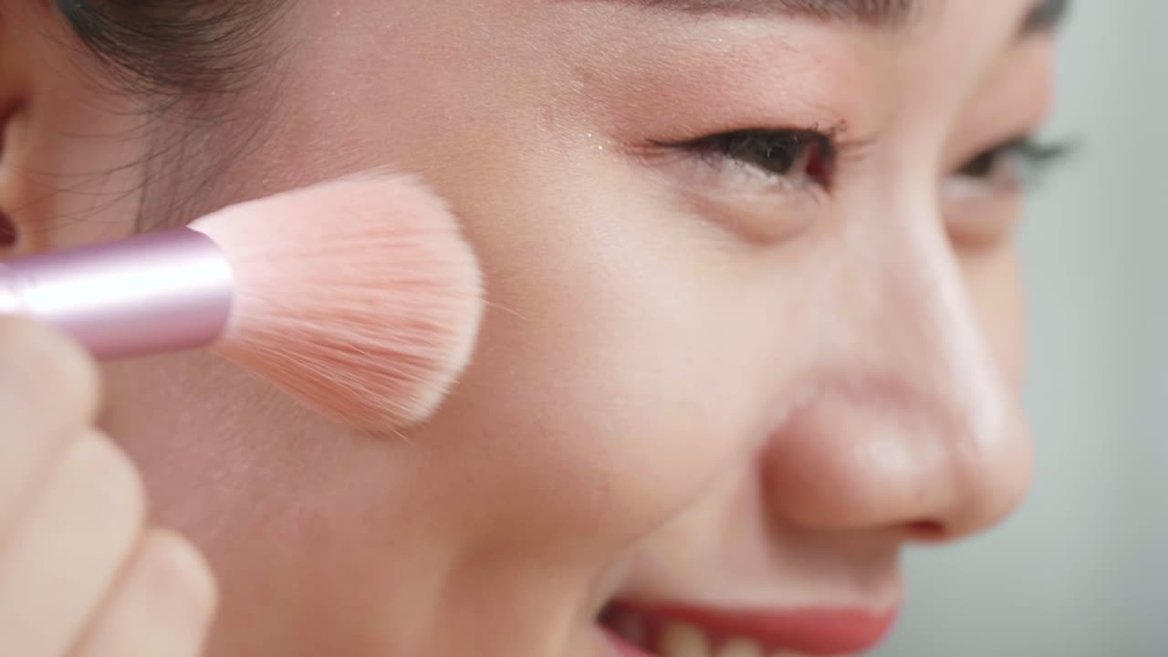 mujer aplicando maquillaje de rubor