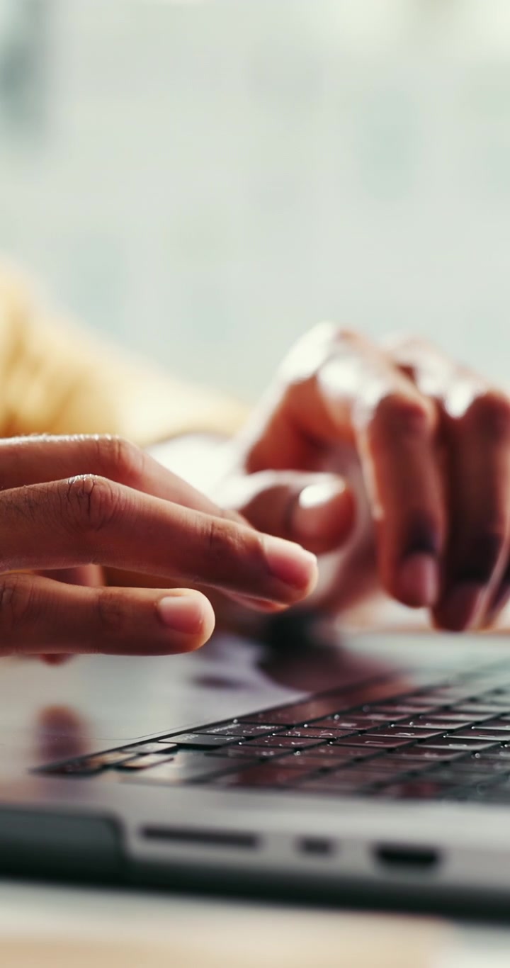 Primo piano di una persona che digita sulla tastiera di un laptop