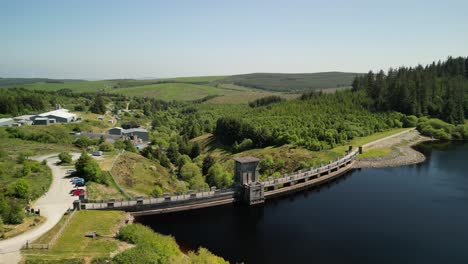 Presa-Del-Embalse-De-Alwen-Conwy,-Gales---Drone-Aéreo-De-Media-Distancia-En-Sentido-Contrario-A-Las-Agujas-Del-Reloj,-Enfoque-En-La-Presa-Y-Revelar-El-Lago---23-De-Junio