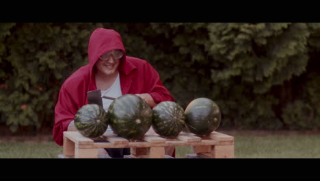 man smashing watermelons with an axe