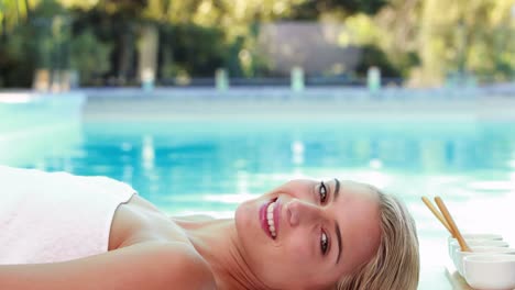 Friedliche-Blondine-Liegt-Auf-Dem-Massagetisch-Am-Pool