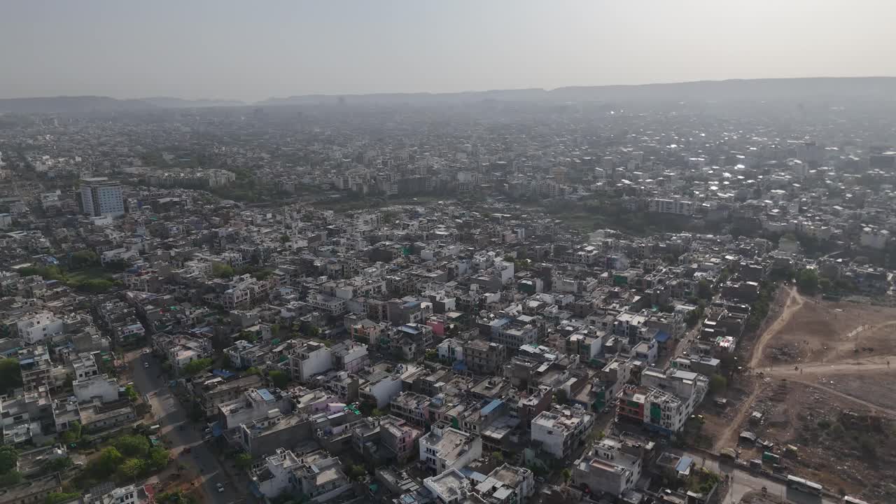 A rising apartment building beside the metro line symbolizes Jaipur’s urban growth.