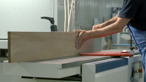 man planing wood on a planer