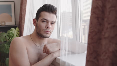 portrait of young caucasian man near window