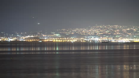 timelapse de la vida nocturna de una ciudad costera lejana