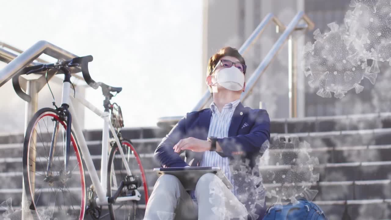 여러 코로나19 세포가 계단에 앉아 있는 얼굴 마스크를 쓴 아시아 남자를 향해 떠다니고 있습니다.