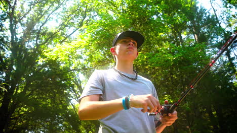 a young man reeling in a fishing line