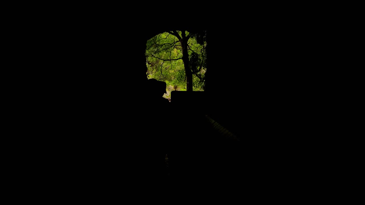 People In Silhouette In A Dark Tunnel Walking Towards The Exit Light At The End Of The Tunnel - 4K