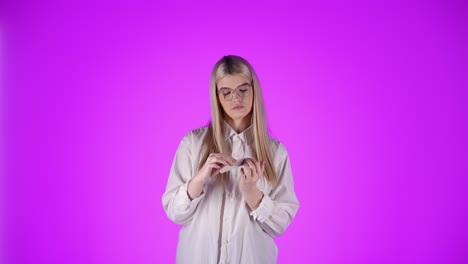 dama rubia caucásica tranquila con actitud seria archiva sus uñas en estudio fondo cromado torso isolatado disparado con gafas