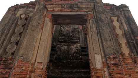 camera pans up ancient temple's weathered facade