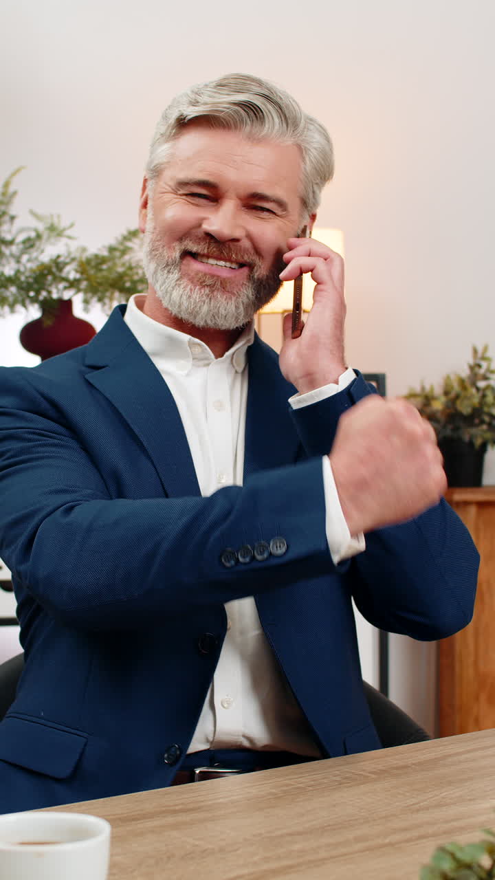 Podnikatel středního věku s chytrým telefonem oslavuje povýšení poté, co se z telefonátu dozvěděl skvělé zprávy.