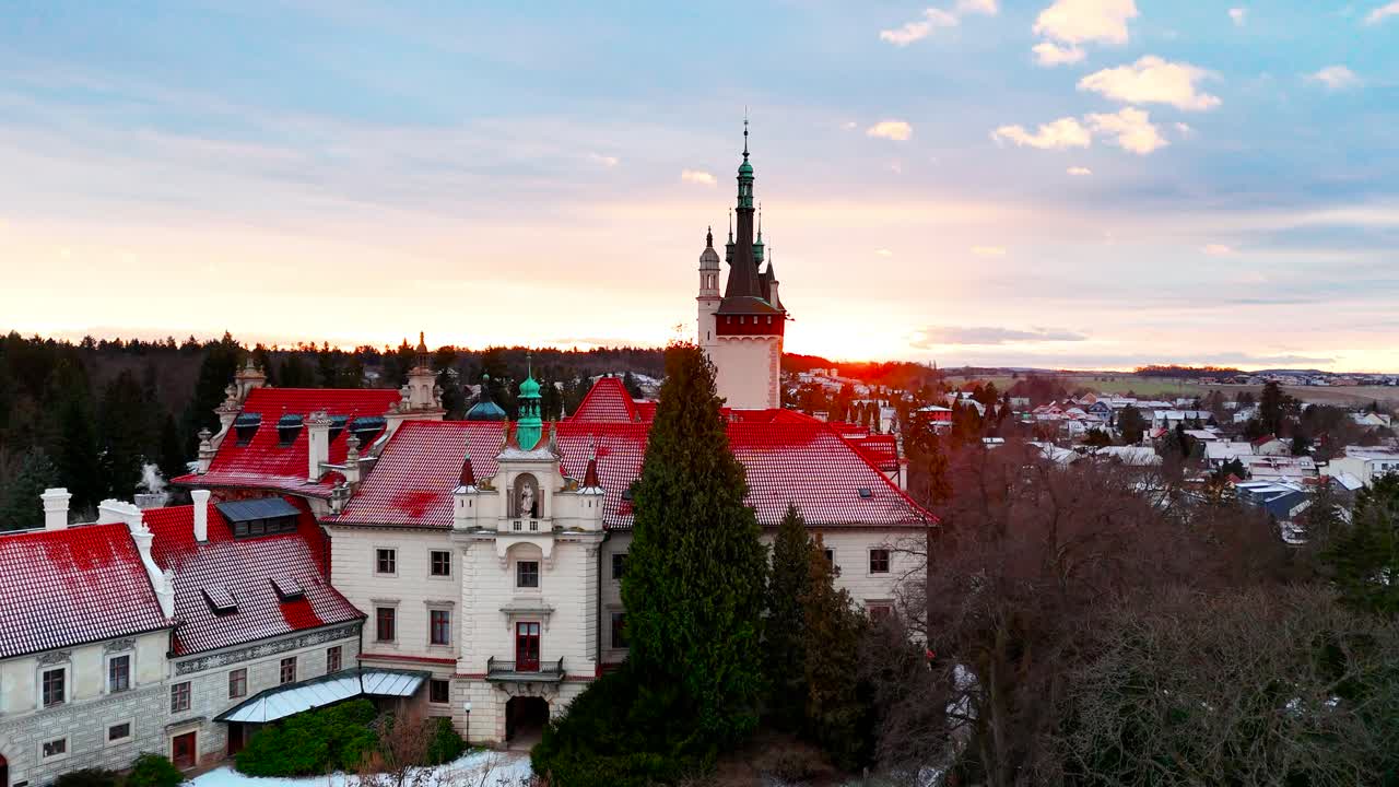 Aerial ascend revealing Pruhonice castle with red roofs at sunset, Czechia