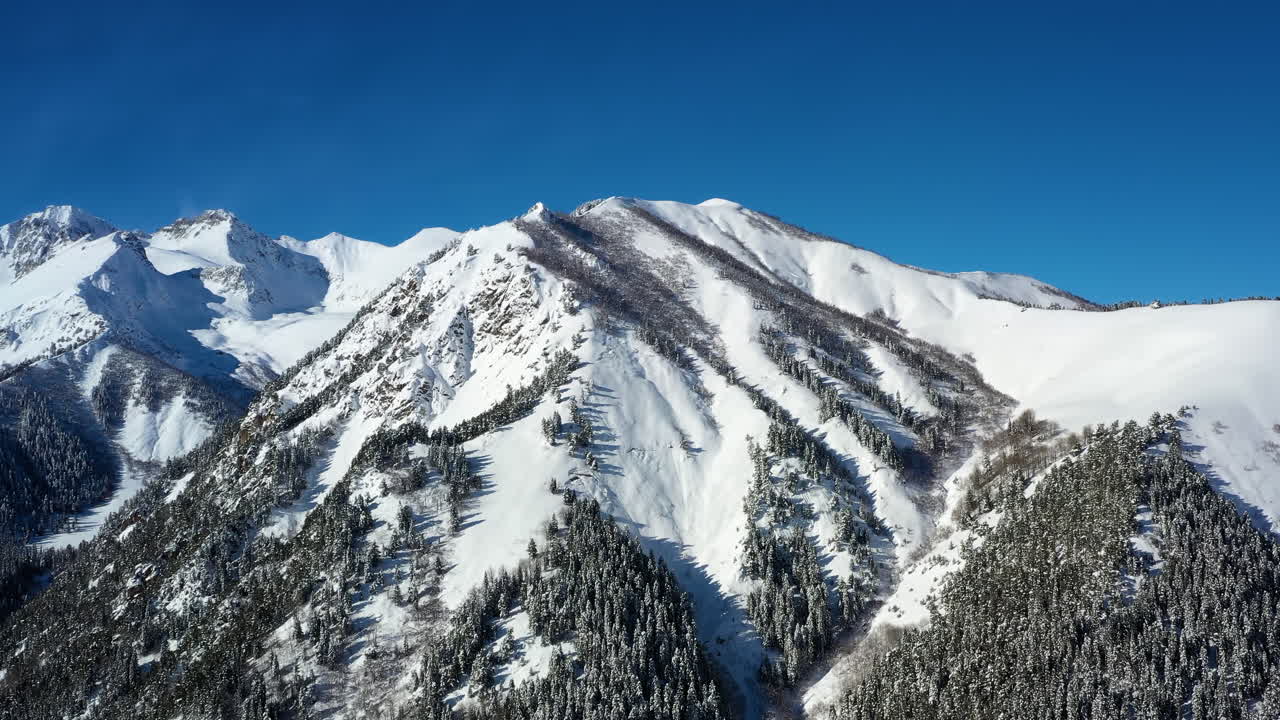 Volo aereo tra le nuvole di montagna sopra splendide vette innevate e ghiacciai.