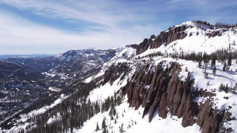 Toma-De-Drones-De-Acantilados-Rocosos,-Paso-De-Montaña-Y-Paisaje-Nevado-De-Colorado-En-El-Soleado-Día-De-Invierno.