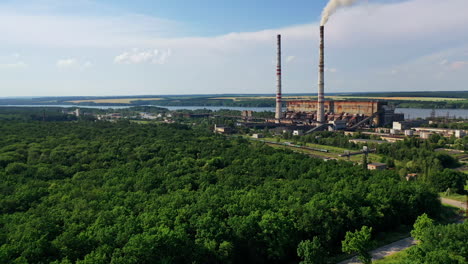 industrial place from above. flying above factory surrounded by green trees