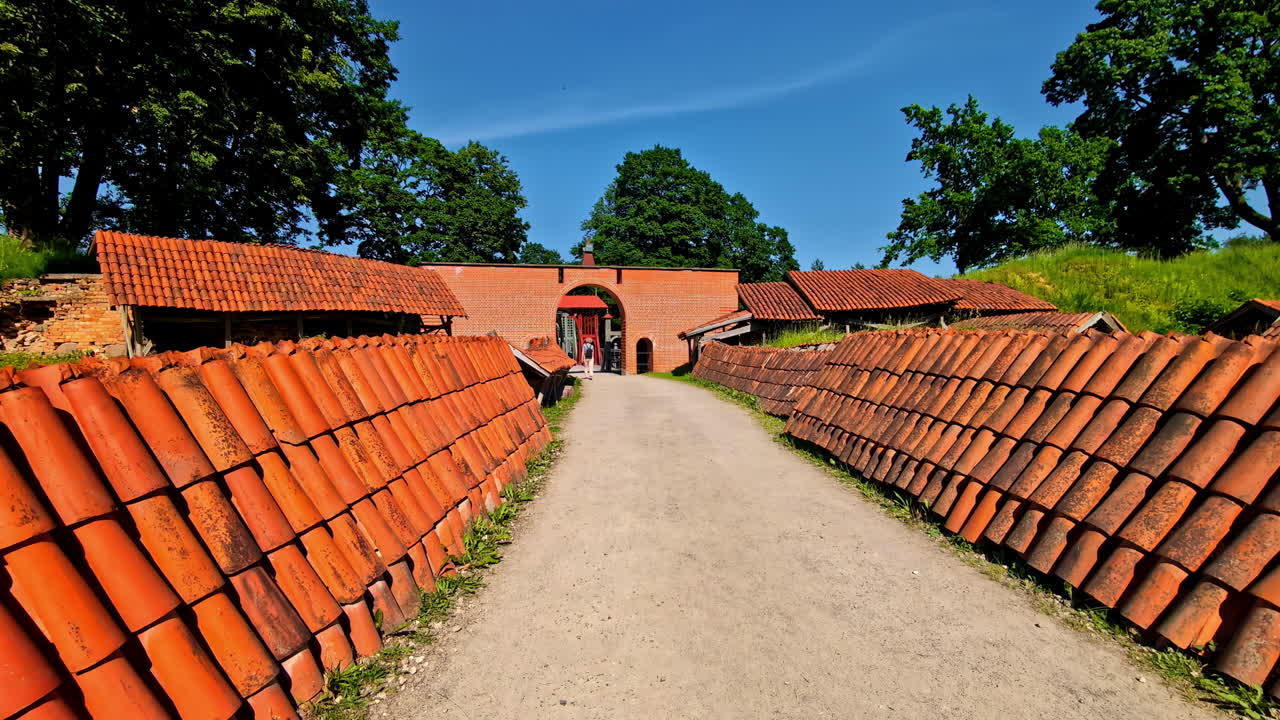 Historic wooden bridge and red-tiled ramp leading to Biržai Castle in Lithuania