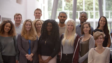 grupo de estudiantes universitarios de pie todavía en el vestíbulo moderno
