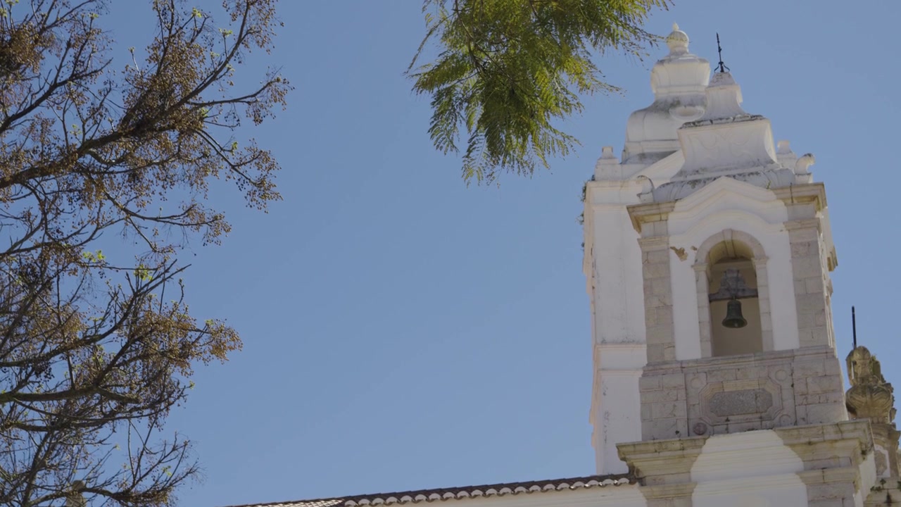 Vista della Chiesa di Santo António a Lagos, Portogallo, incorniciata dalla vegetazione e da un cielo azzurro limpido