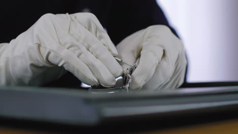 close-up footage of a professional watch collector attaching the steel bracelet to the luxury watch after adjusting the links