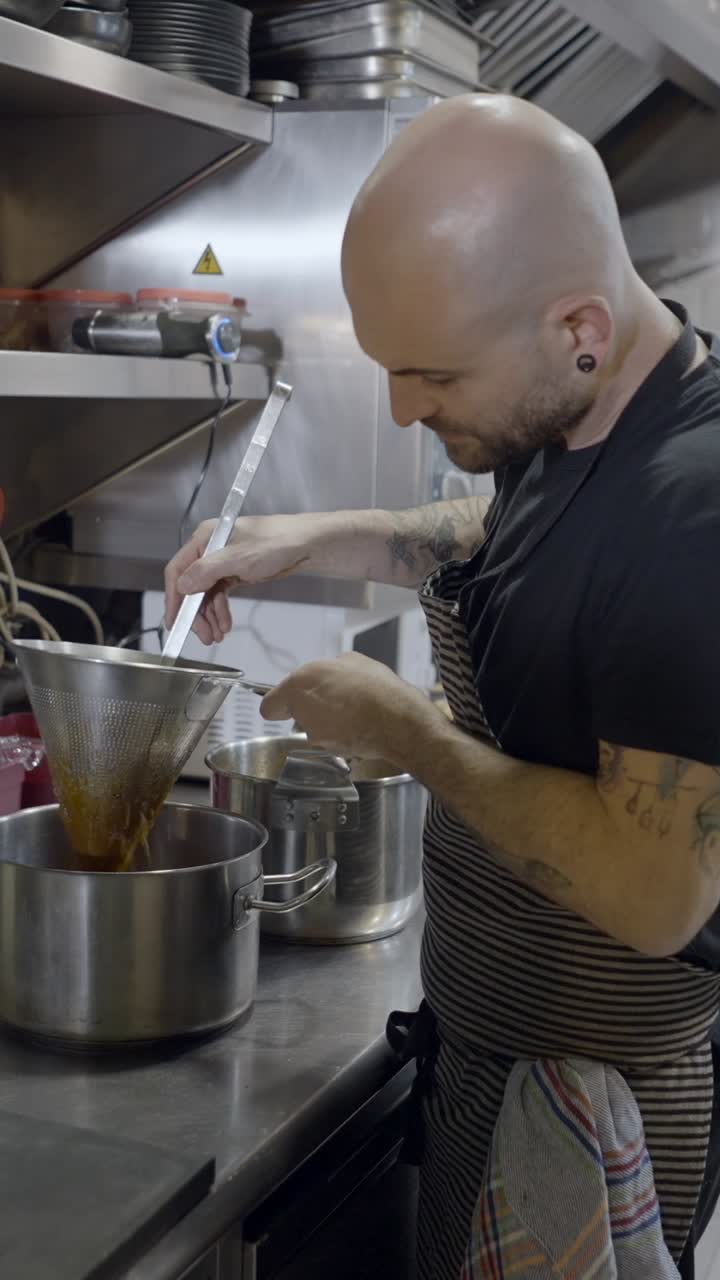 A chef straining liquid in a professional kitchen