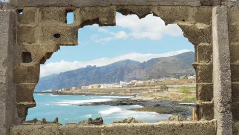 pared de piedra rota y la pequeña ciudad de la isla de tenerife en el horizonte