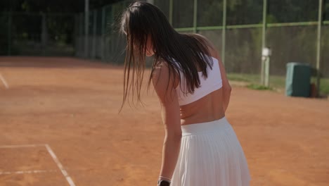 beautiful tennis girl practicing serve on outdoor court