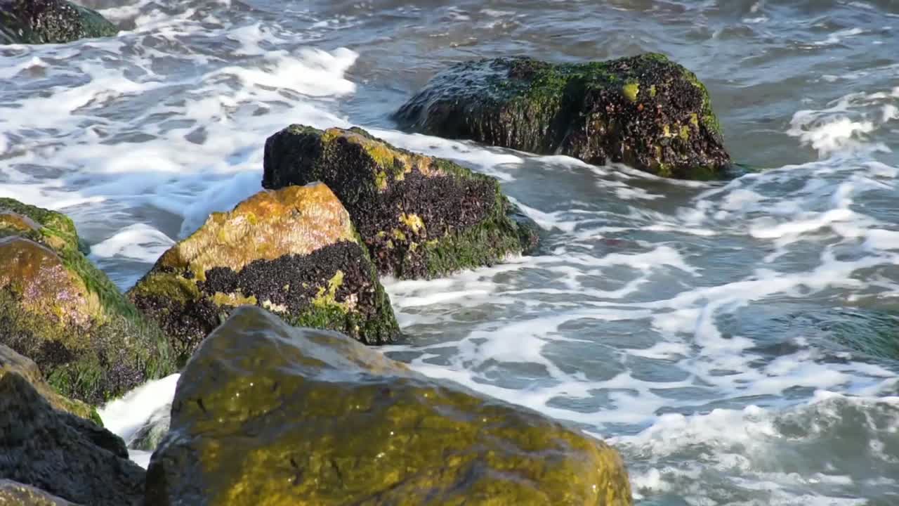 pequeñas olas rompiendo en las rocas a orillas del mar negro