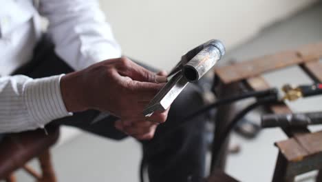 a man measures a pipe with a ruler