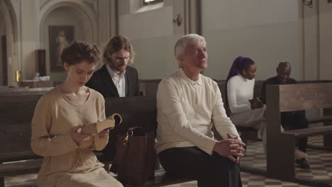 parishioners praying while caucasian man entering christian church