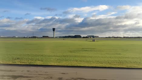 view from airplane window on the runway at copenhagen airport. control tower visible after landing