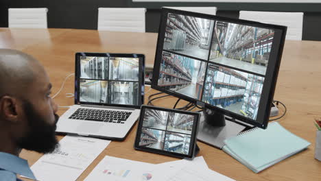 oficial de seguridad afroamericano con negocios cámaras de cctv vistas en tres pantallas, cámara lenta