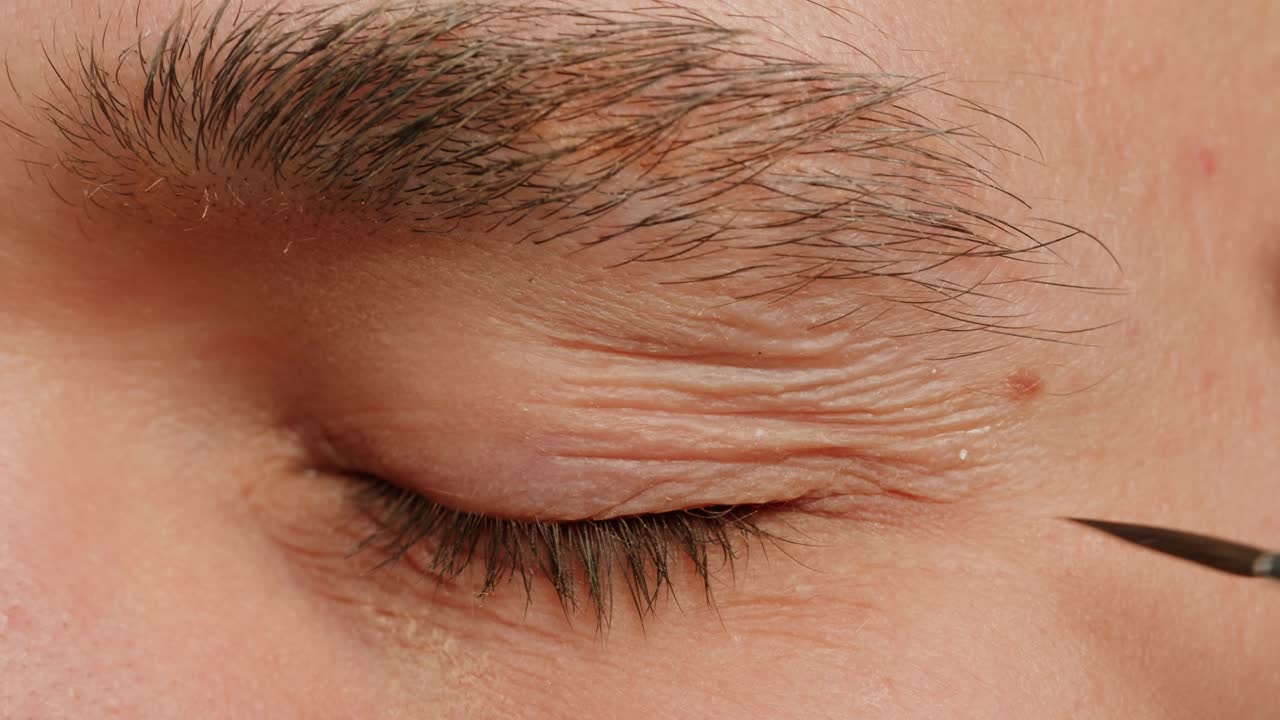 Make up artist making Disheveled blond beard for a man in theater, actors sfx cinema make up, close-up. Mens fashion, halloween style. making old guy.