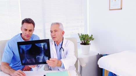 Männlicher-Arzt-Und-Kollege-Untersuchen-Röntgenaufnahmen