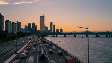 Timelapse-De-La-Autopista-Olímpica-De-La-Hora-Del-Atardecer-De-Seúl-Del-Tráfico-De-Cas-Con-63-Edificios,-Rascacielos-De-Negocios-Yeouido-Y-Bloques-De-Apartamentos-Residenciales-En-Segundo-Plano---Zoom-En-Movimiento