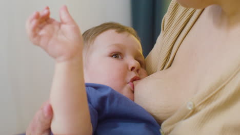 close up of an unrecognizable mother breastfeeding her baby boy at home 1