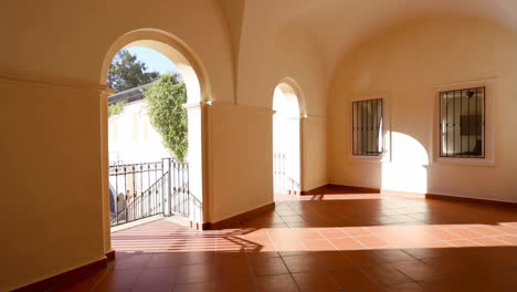 sunny architectural corridor with arches and tiled floor