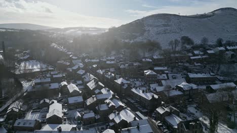 cold snowy winter cinematic aerial view cityscape townscape with snow covered roof tops panorama 4k delph village west yorkshire, endland