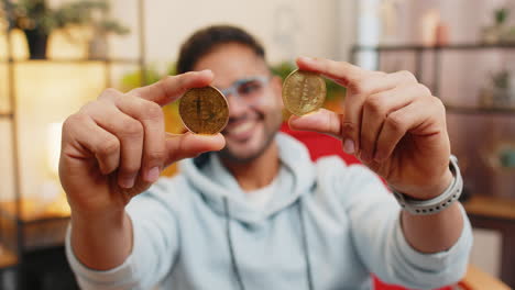 hombre indio comerciante de acciones ganando bitcoins monitoreo en línea operaciones comerciales minería mantener monedas btc