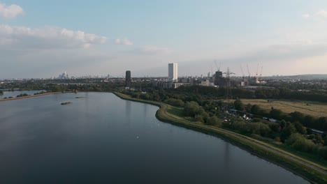 Steigende-Drohnenaufnahme-Von-Stromleitungen,-Die-In-Die-Stauseen-Von-Walhamstow-Im-Zentrum-Von-London-Führen