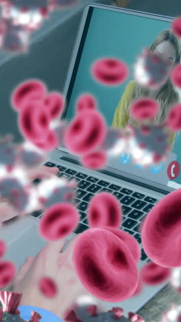 animación de células de covid-19 y glóbulos rojos sobre una mujer de negocios en una videollamada portátil
