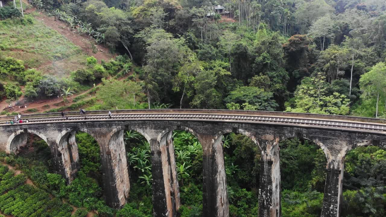 Aerial view of iconic Nine Arches Bridge with train tea fields and people in Ella Badulla Sri Lanka