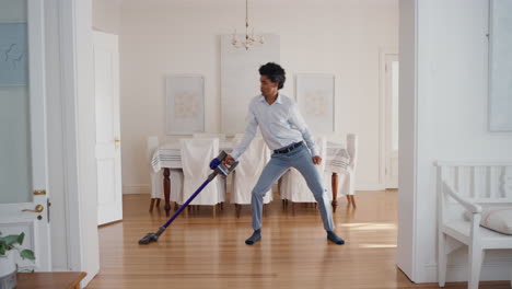 funny man dancing with vacuum cleaner at home celebrating success with weird victory dance moves having fun doing chores feeling successful 4k