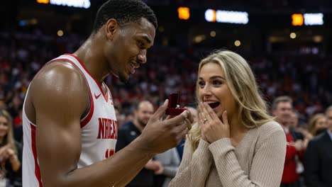 heartfelt proposal: a basketball player surprises his partner with an engagement ring during a game, capturing the joy and excitement in a memorable moment