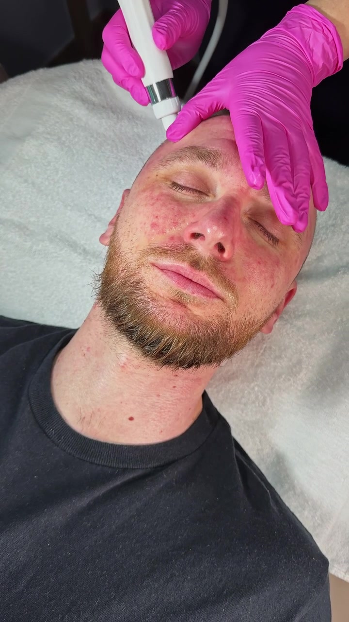 Uomo che riceve un trattamento viso con dispositivo in una spa di giorno