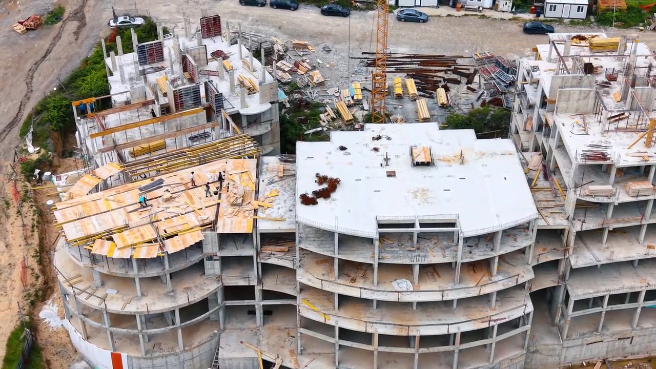 Vista dall'alto della struttura in cemento armato di un edificio multipiano. Panoramica dall'alto di solai e colonne in cemento non finiti in un cantiere edile moderno.