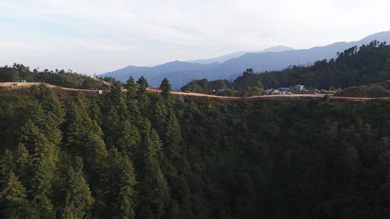 Nefes kesen bir drone videosu, Katmandu Vadisi'nin altında kalan yemyeşil dağların ötesinde yükselen Himalayaları gösteriyor. Bu tek karelik kompozisyon, Nepal'in alp zirvelerini, yemyeşil tepelerini ve şehir manzarasını vurguluyor.