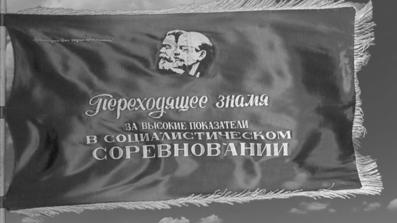 en el estilo de un noticiero en blanco y negro, una bandera soviética que representa a marx y lenin vuela en cámara lenta