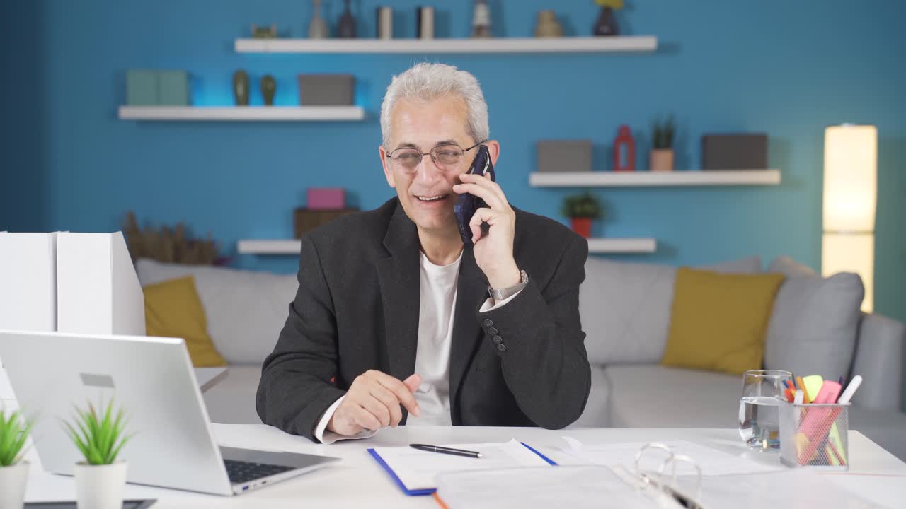 Home office worker man talking on the phone happily.